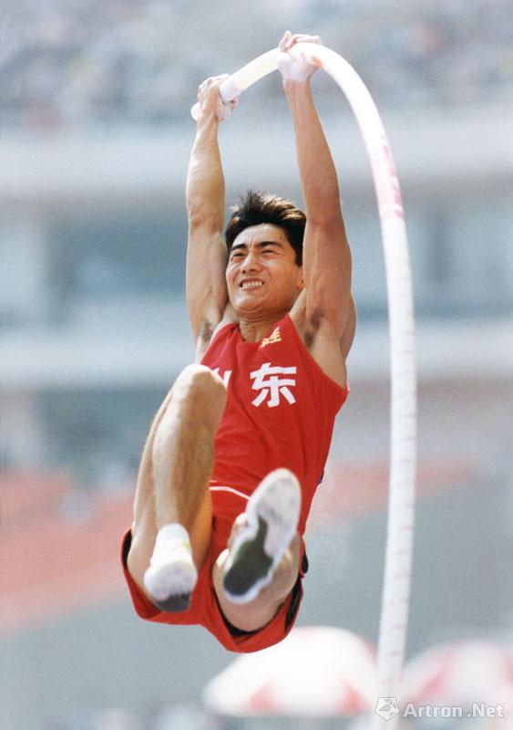 《腾空而起》摄于1997年上海第八届全国运动会男子撑杆跳决赛，山东队夺得冠军。图为：山东队夺冠起跳瞬间。