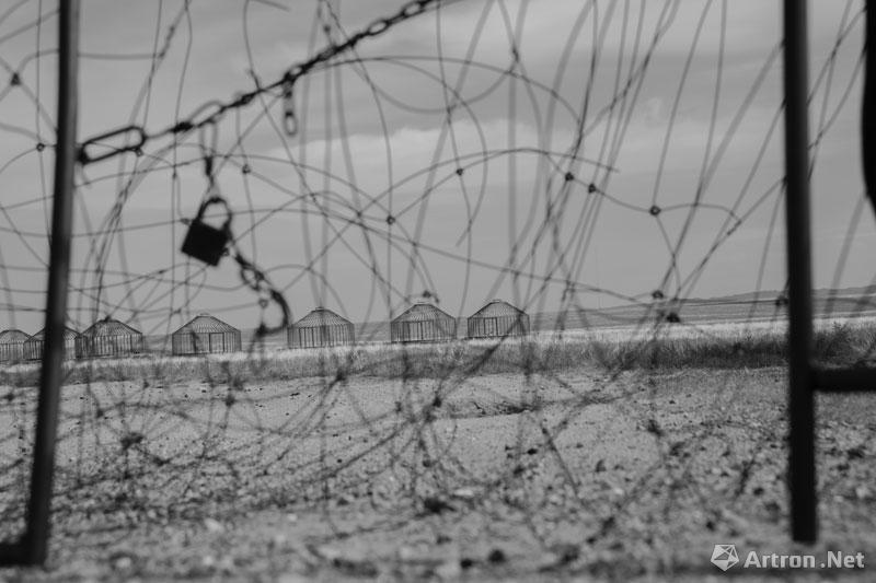 董斯洋作品：2015年9月27日，锡林郭勒盟苏尼特左旗，透过网围栏远眺，是一座荒废的旅游区。